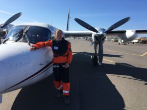 Megan prepares to board a twin-engine Turbo Commander in Utqiaġvik (pronounced oot-kay-ahg-vik), Alaska to conduct surveys. If conditions are optimal, her crew can make two survey flights in a 12-14 hour day, which includes time flying, refueling, data collection, and a survey report.